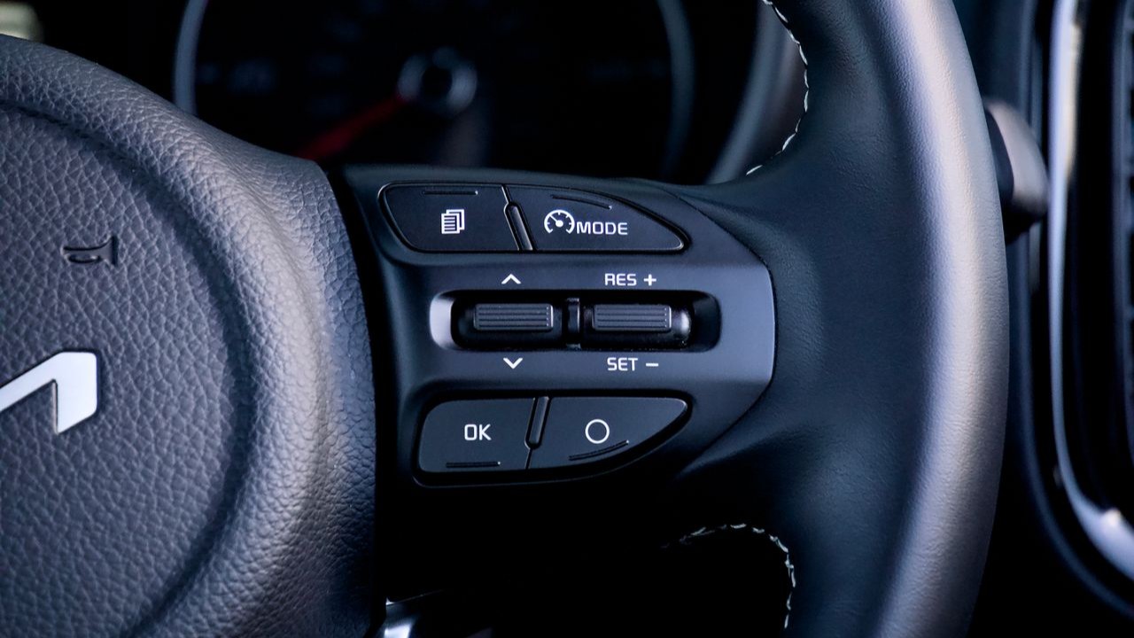 Cruise control bediening op het stuur van een moderne auto met knoppen voor snelheid instellen en hervatten
